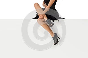 Legs woman wearing high heels shoes sitting on bench.