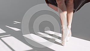 Legs of young dancers, class of ballet. Ballet dancer in a red skirt. Movement with the foot. Pointe shoes.