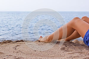 Legs of a young girl on a sandy beach