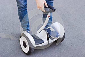 Legs of young man stepping on a self-balancing scooter