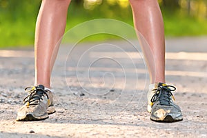 Legs of young sport woman staing on the road
