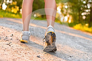 Legs of young sport woman walking on the road