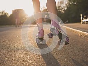 Legs of young woman roller skating in park