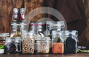 Legumes and beans. Dried, raw and fresh. Lentils, chickpeas, mung beans, soybeans, edamame, peas in glass jars. Healthy diet food