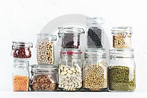 Legumes and beans. Dried, raw and fresh. Lentils, chickpeas, mung beans, soybeans, edamame, peas in glass jars. Healthy diet food