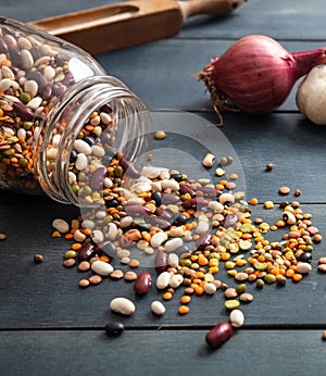 Legumes mix spilled on blue tabletop, closeup view