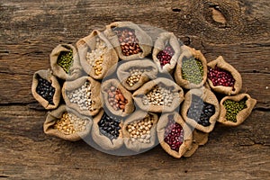 Legumes in sack on wooden background