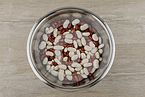 Legumes - a source of protein and micronutrients: red and white beans in a metal plate on the table, in the center; a vegetarian