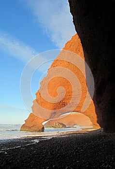 Legzira stone arch on beach in Morocco photo