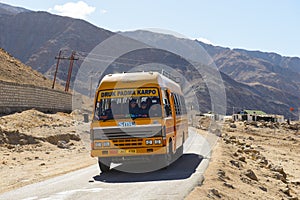 Leh, India - April 12, 2016 : A school bus running pass the road on high altitude Ladakh-Leh road in Himalayan mountain, state of