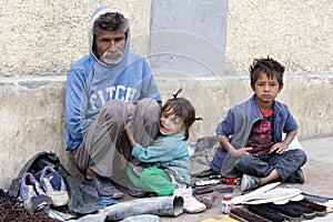 Beggar family begs for money from a passerby in Leh. India