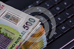 Lei banknotes on keyboard. Selective focus on stack of LEI romanian money