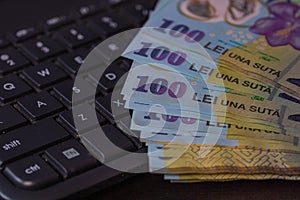 Lei banknotes on keyboard. Selective focus on stack of LEI romanian money
