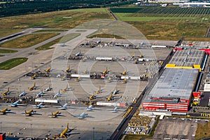 Leipzig, DHL cargo hub with main cargo apron, main buildings and hangar and many cargo airplanes parked on apron - aerial view