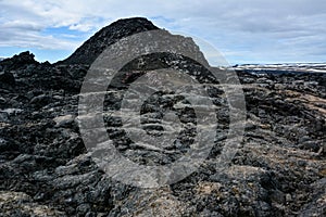 Leirhnjukur old black lava field and blue sky in Iceland, overcast day in summer , film effect