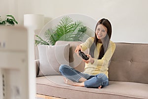 Leisure activity concept, Young woman sitting on couch to control joystick while playing video game