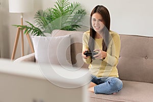 Leisure activity concept, Young woman sitting on couch to playing video games with joystick console