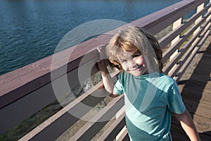 Leisure break. Happy boy child stand at promenade railing. Leisure time. Summer vacation