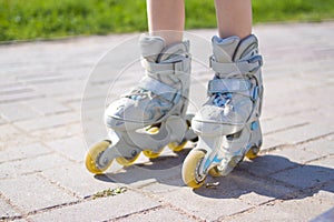 Kids legs in roller skates - leisure, childhood, outdoor games and sport concept photo