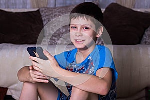 leisure, children, technology, internet communication and people concept - smiling boy with smartphone texting message or playing