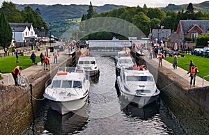 Leisure cruiser boats pass through the staircase locks at Fort Augustus in the Great Glen, Scotland, UK