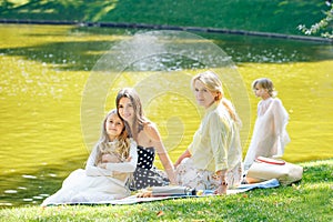 Leisure, holidays and people concept - happy female family having festive dinner or summer garden party