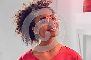 Leisure at Home. African teenager girl in glasses standing laughing playful close-up