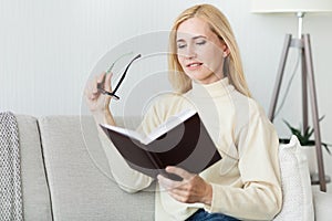 Leisure and literature concept. Middle aged woman reading book