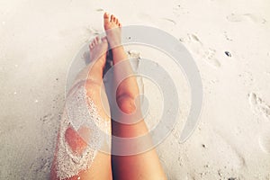 Leisure in summer - Beautiful women tan. relax on beach with sand of heart shape photo