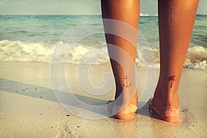 Leisure in summer - Rear of beautiful women tan relax on beach with tattoo on foot