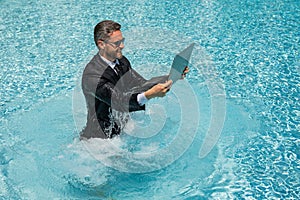 Leisure weekend and remote freelance work. Crazy comic business. Funny businessman in suit with laptop in swimming pool