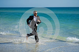 Leisure weekend and remote freelance work. Crazy comic business man in suit rest on sea bech. Funny businessman with