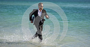 Leisure weekend and remote freelance work. Crazy comic business man in suit run on sea. Funny businessman with laptop