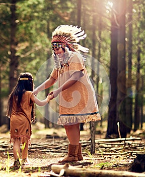 Lemme see your rain dance. a little girl and her mother dancing while playing dressup in the woods.