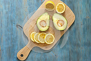 Lemon and avocado, fresh fruit on wooden board