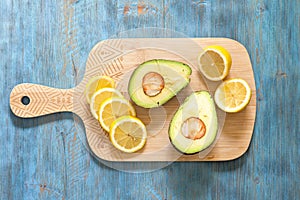 Lemon and avocado, fresh fruit on wooden board