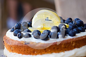 Lemon blueberry naked cake with blueberries on the top and mascarpone butter frosting