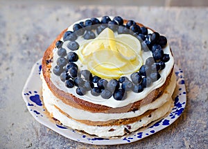 Lemon blueberry naked cake with blueberries on the top and mascarpone butter frosting