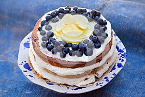 Lemon blueberry naked cake with blueberries on the top and mascarpone butter frosting