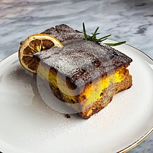 Lemon brownies with dried lemon sliced on a white ceramic plate