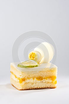 Lemon cake decorated with lime slice on background