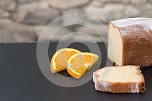 Lemon cake on a roof slate decorated with two pices of orange fr