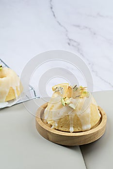 Lemon cake with sugar frosting on marble table. Healthy dessert. Delicious breakfast, traditional tea time treat.