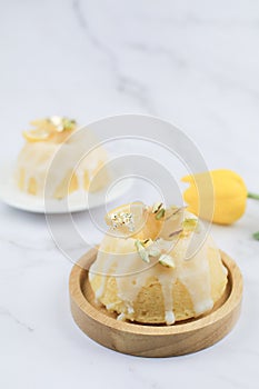 Lemon cake with sugar frosting on marble table. Healthy dessert. Delicious breakfast, traditional tea time treat.