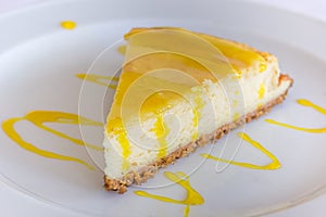 Lemon cheese cake with sauce on a white plate