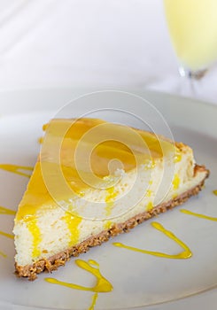 Lemon cheese cake with sauce on a white plate