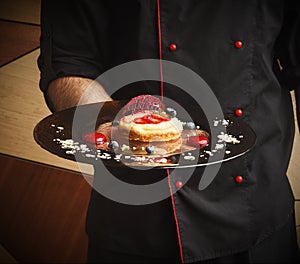 Lemon cheesecake with berry spheres served at modern restaurant