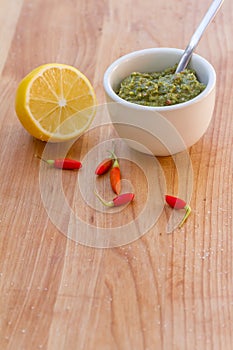 Lemon, chilli pepper and source on wooden cutting board, cooking