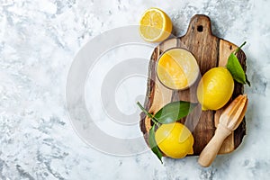 Lemon curd in a glass jar with fresh lemons.