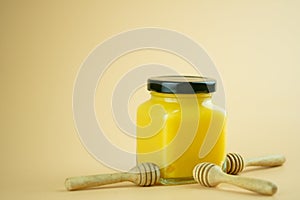 Lemon curd in a glass jar. Nearby with honey dipper stick